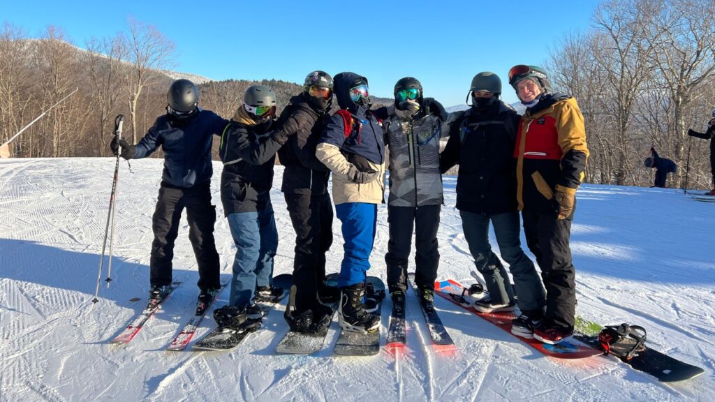 A group of friends skiing and snowboarding together.