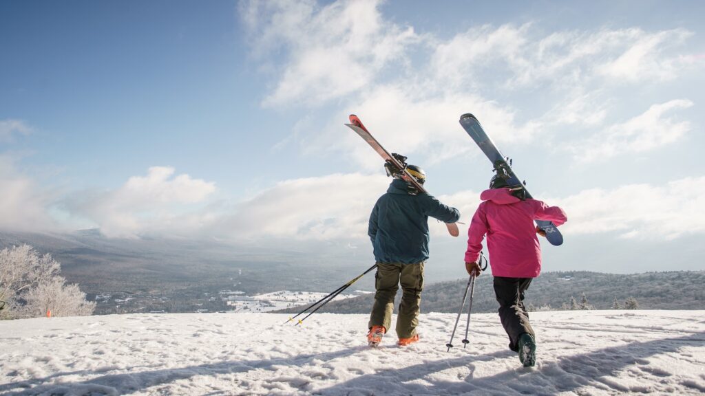 Two skiers carrying their gear at Bretton Woods in New Hampshire.