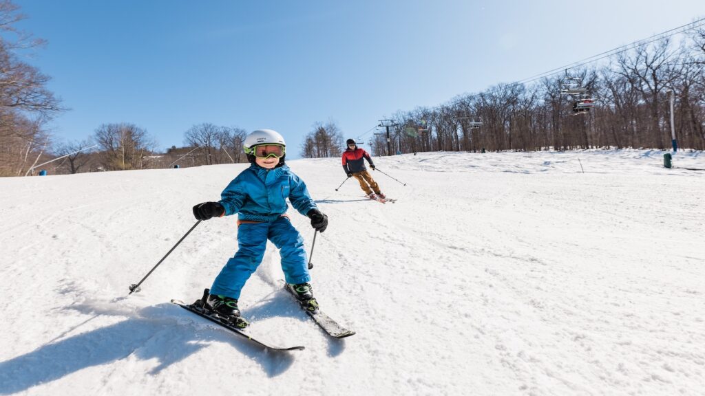 An adult and child skiing at Canmore Mountain Resort.