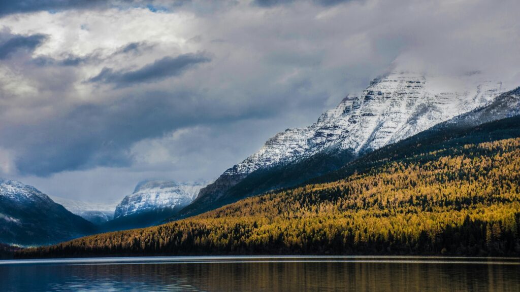 Snow covered mountains surrounded by fall foliage at Glacier.