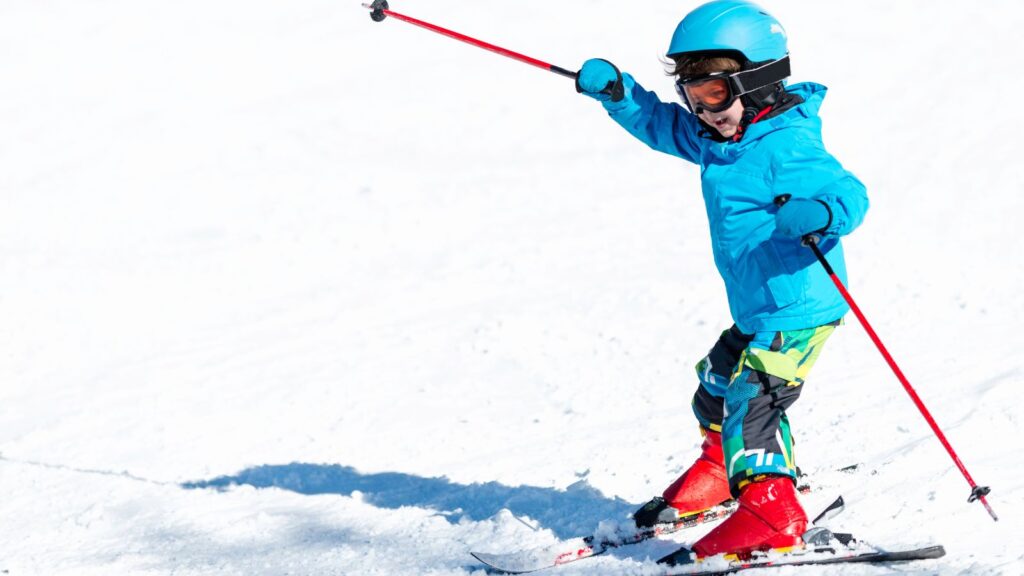 A kid skiing in a bright yellow jacket.