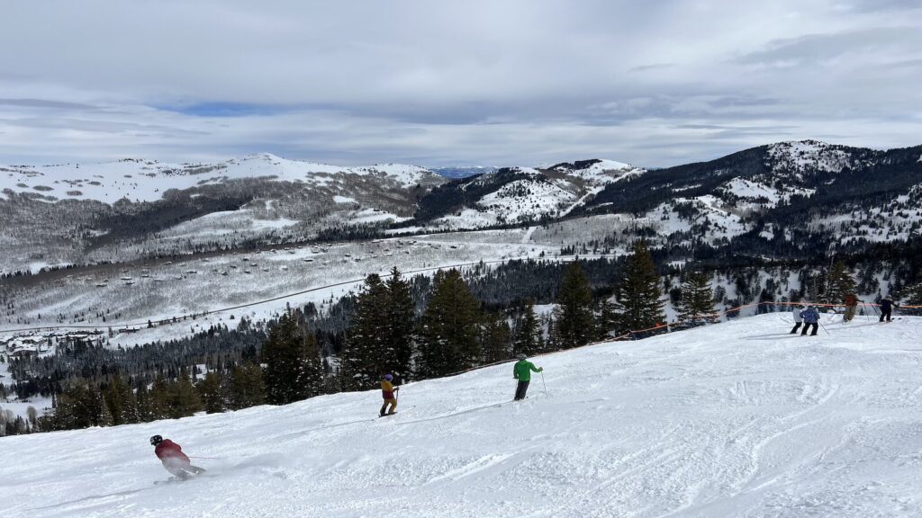 Ski slopes in Utah with a bunch of skiers going down.