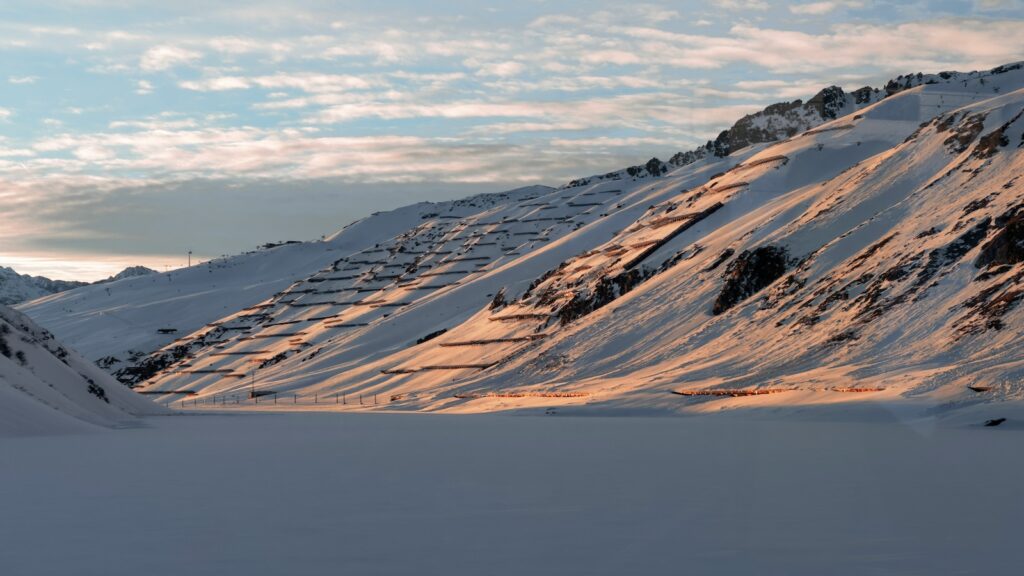 Andermatt snowy mountains during sunset.