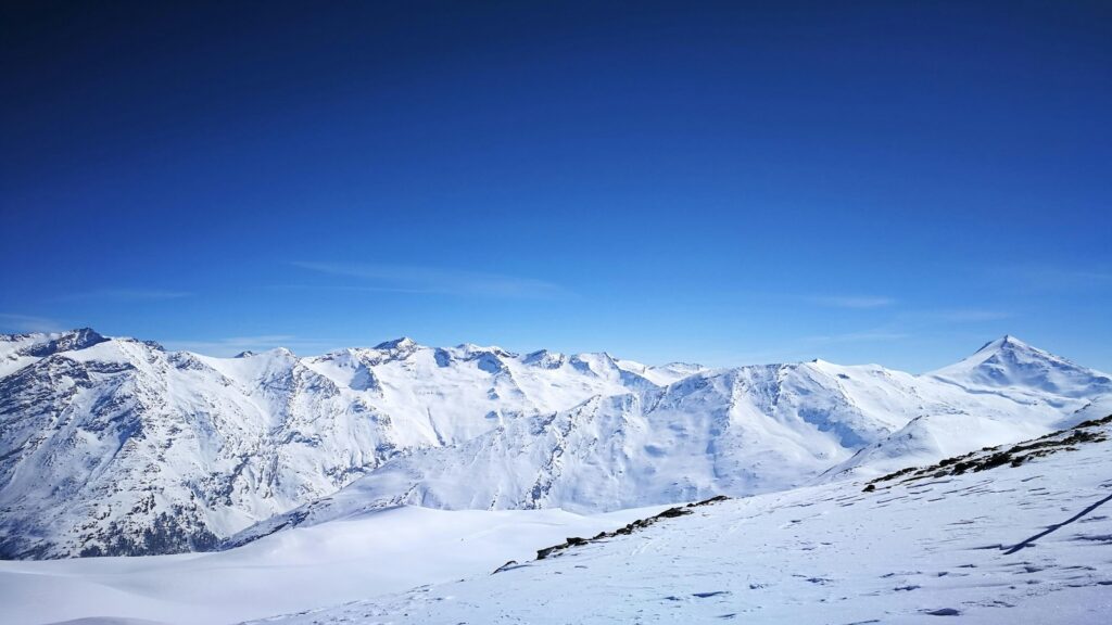 Saas-Fee snow capped mountains with blue skies.