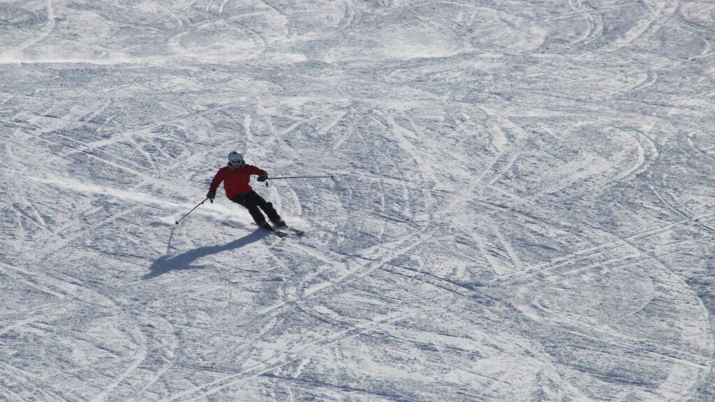 A skier going down a groomed run in Italy.